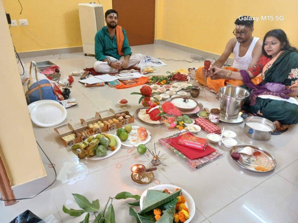 Pandit Sourabh Thakur performing a Hindu puja ceremony with a family couple inside their Kolkata home.